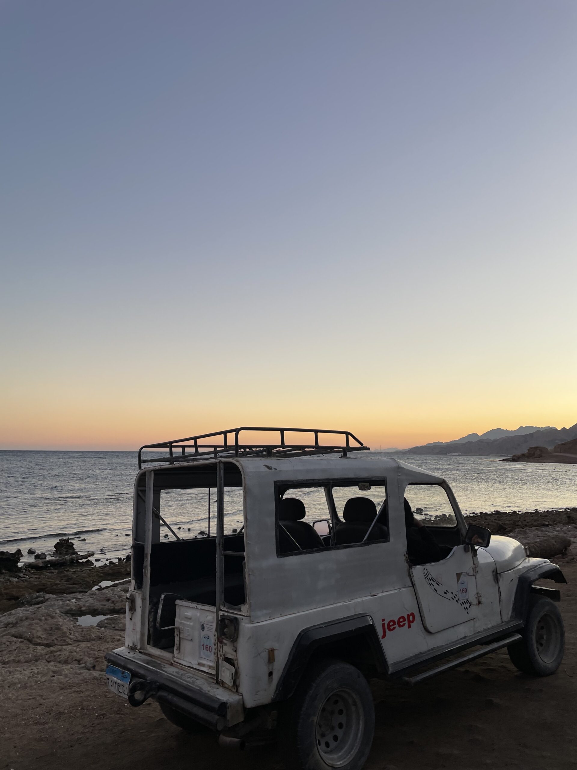 Sunset over the Red Sea with a Jeep in Dahab Egypt