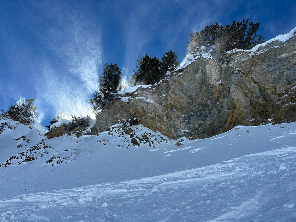 rock with sun behind and blue sky in Alta, Utah