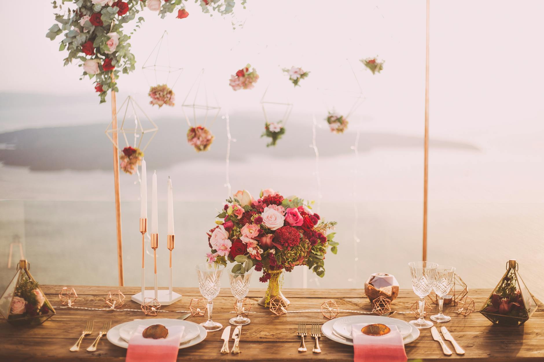 pink and red roses centerpiece near silverwares