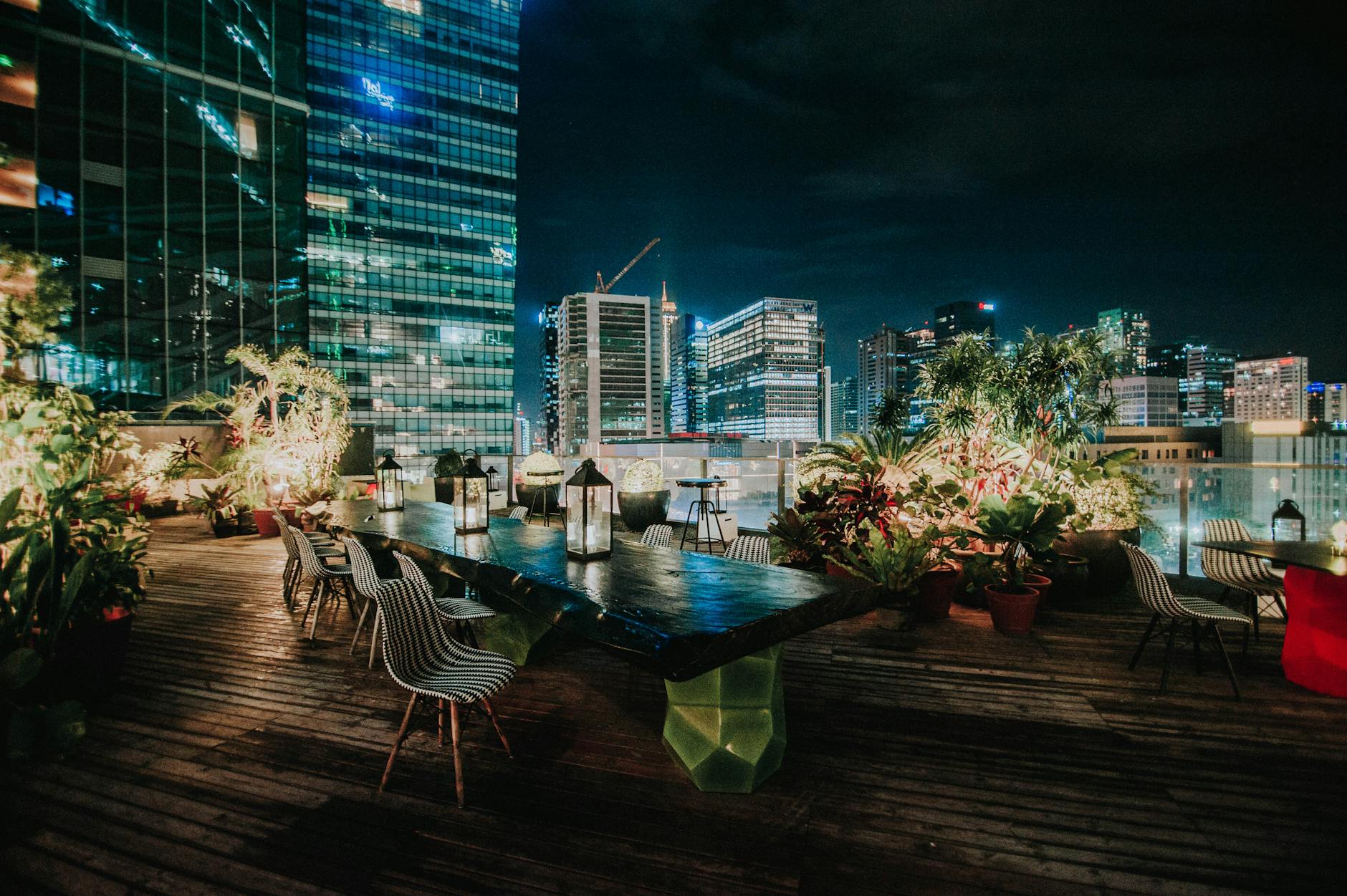 view of the cityscape from a rooftop garden restaurant at night