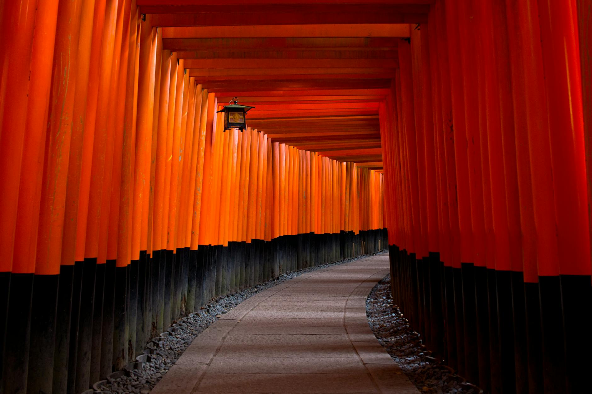 gray concrete pathway between red and black pillars